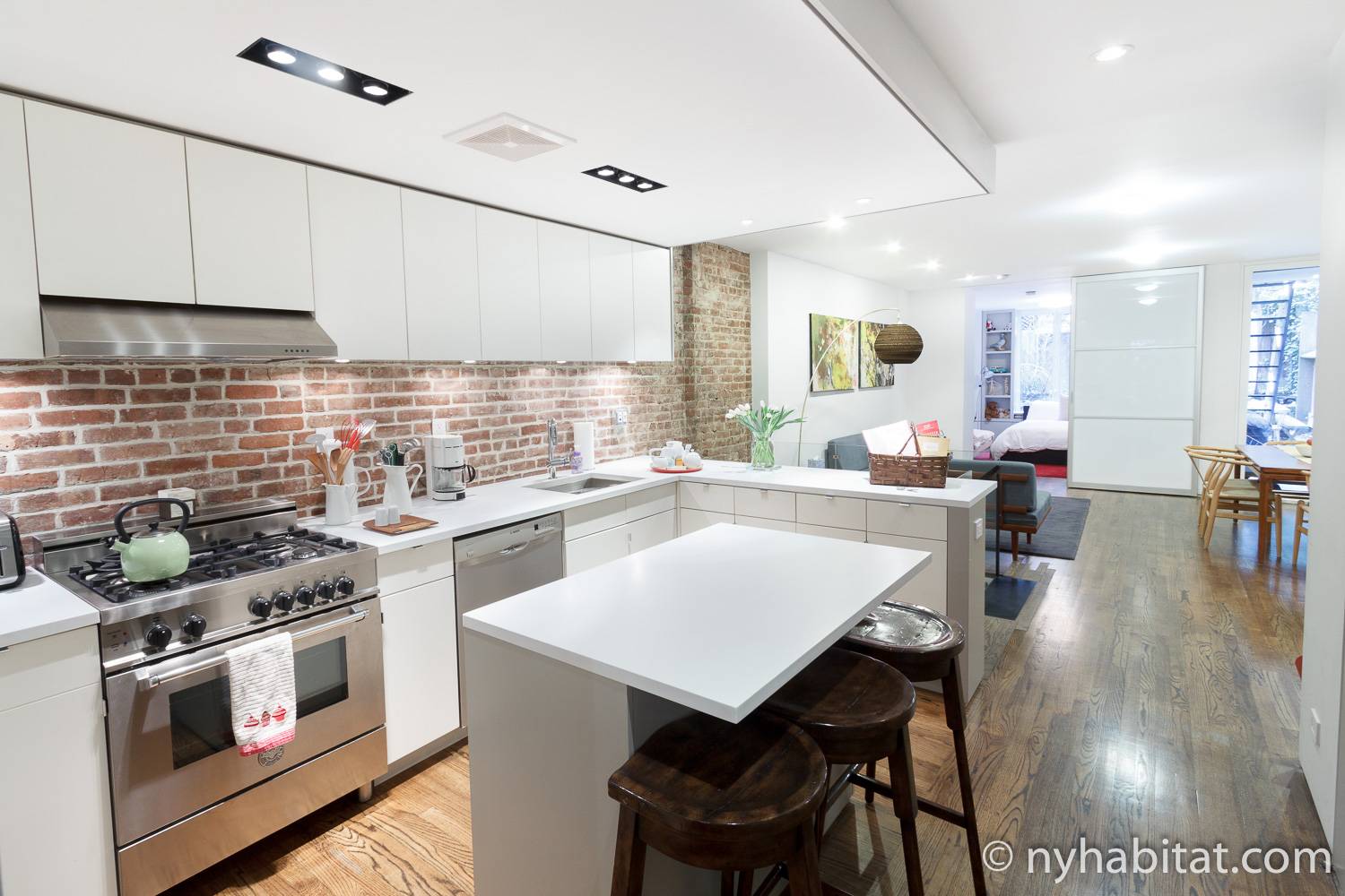 Immagine della cucina aperta della casa vacanze dell’Upper East Side NY-15650 con armadietti bianchi e muro in mattoni a vista