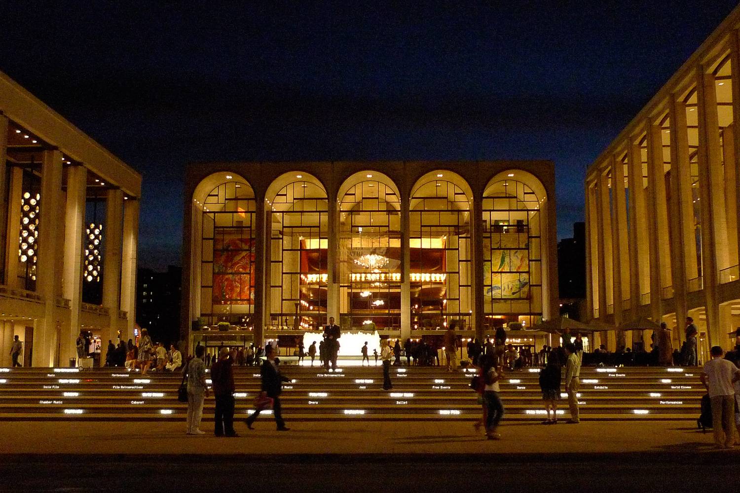 Immagine di Lincoln Center di notte con persone che vi camminano.