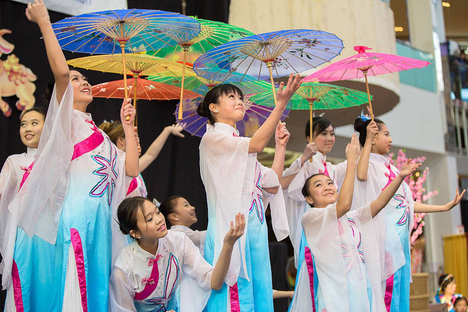 Immagine di donne asiatiche con vestiti tradizionali che ballano con ombrelli parasoli