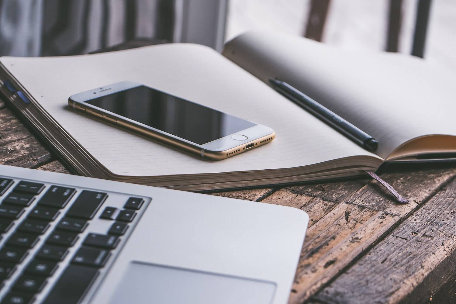 Imamagine di un telefono, di un portatile e di un giornale aperto.
