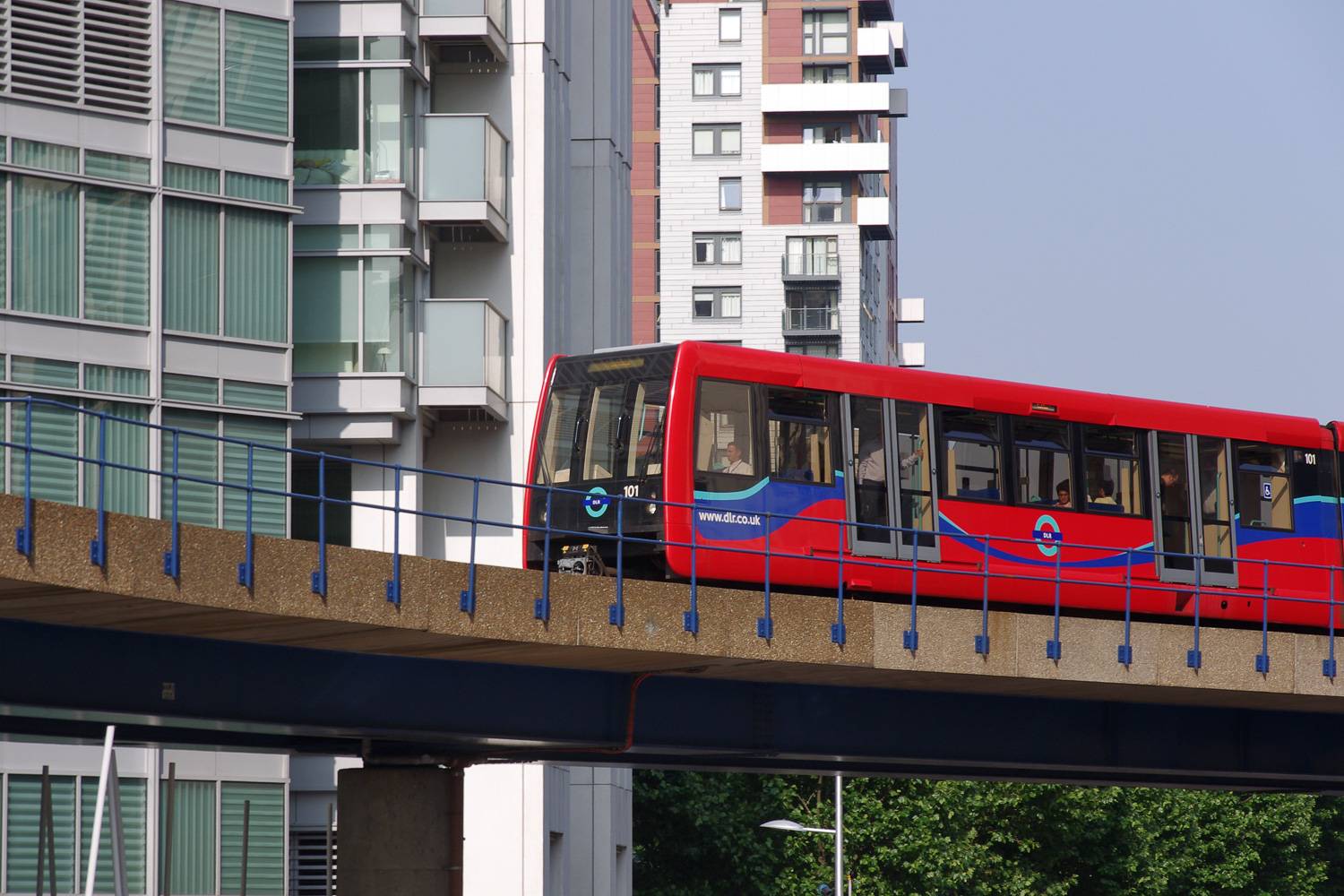 Immagine di un treno DLR rosso che viaggia attraverso i Docklands di Londra.