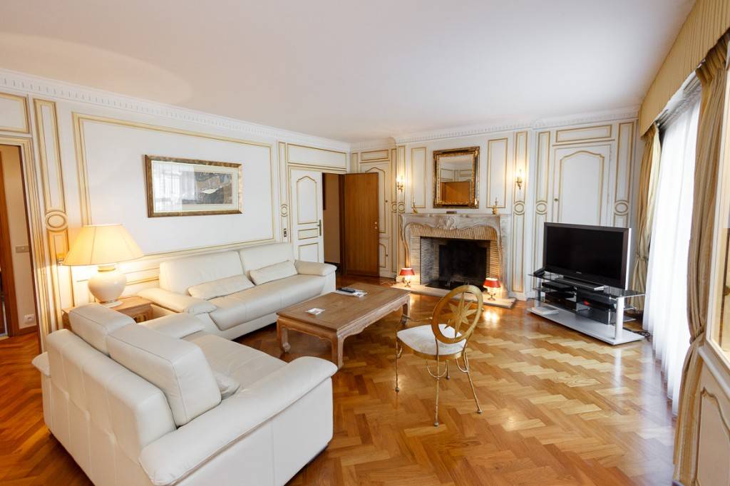 Imagen de un salón en Trocadero, con suelos de parqué y chimenea