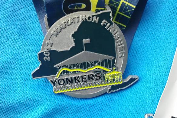 Fotografía de un corredor con el pin del maratón de Yonkers