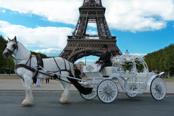 Imagen de un coche de caballos a los pies de la Torre Eiffel