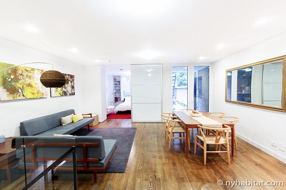 Imagen del salón y la mesa de comedor del NY-15650 con el dormitorio al fondo