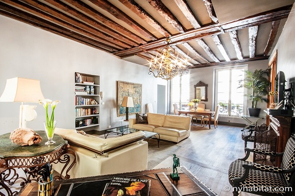 Imagen del salón del PA-1344 con vigas de madera vistas y lámparas de araña