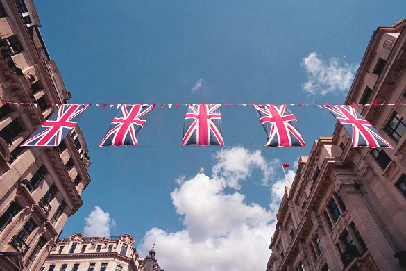 Imagen de la bandera del Reino Unido ondeando entre edificios