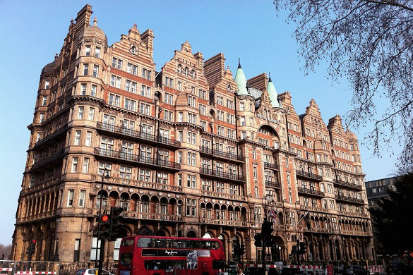 : Imagen de la fachada del antiguo Hotel Russell delante de un autobús de dos pisos