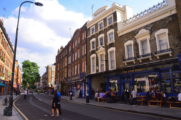 Imagen de una calle de Londres con pubs y cafés