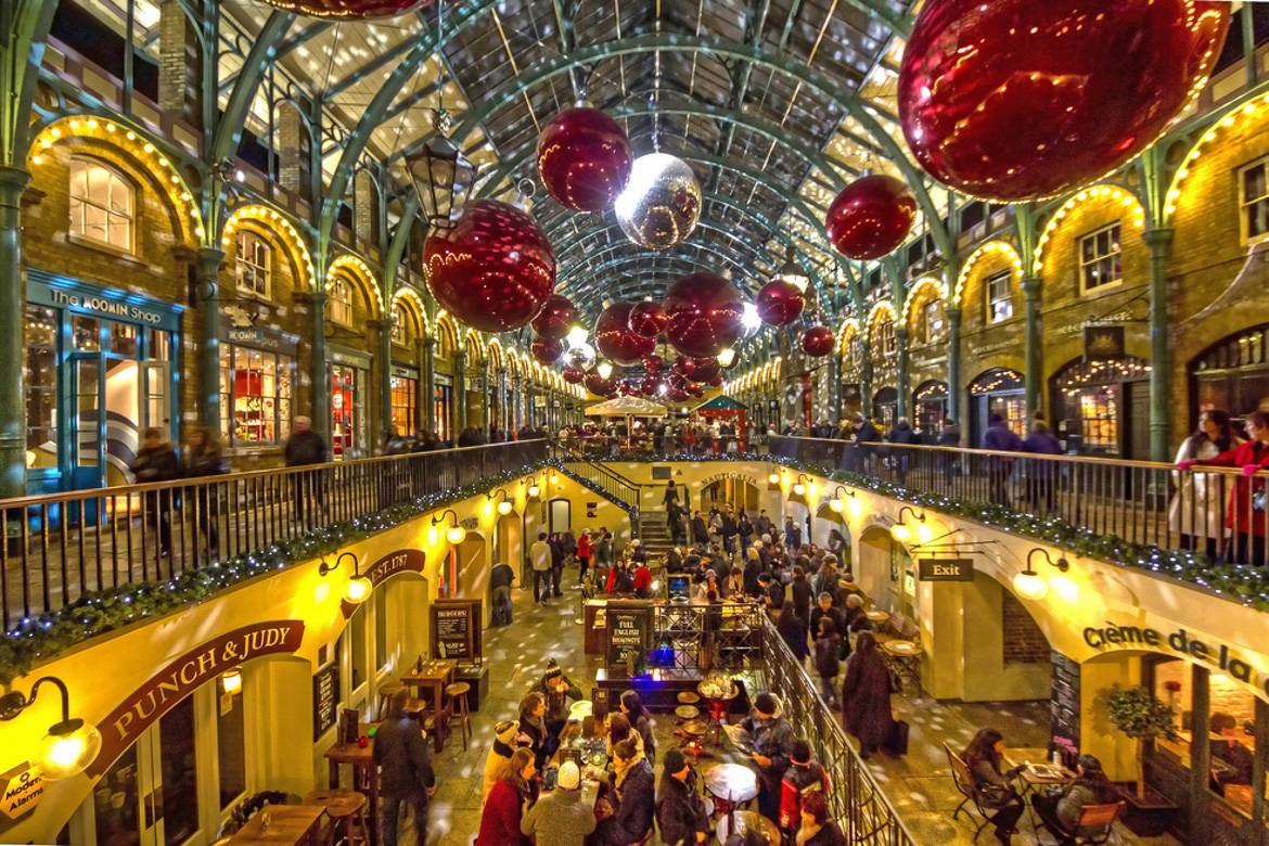 Imagen de las tiendas de Covent Garden con luces y adornos colgados del techo.