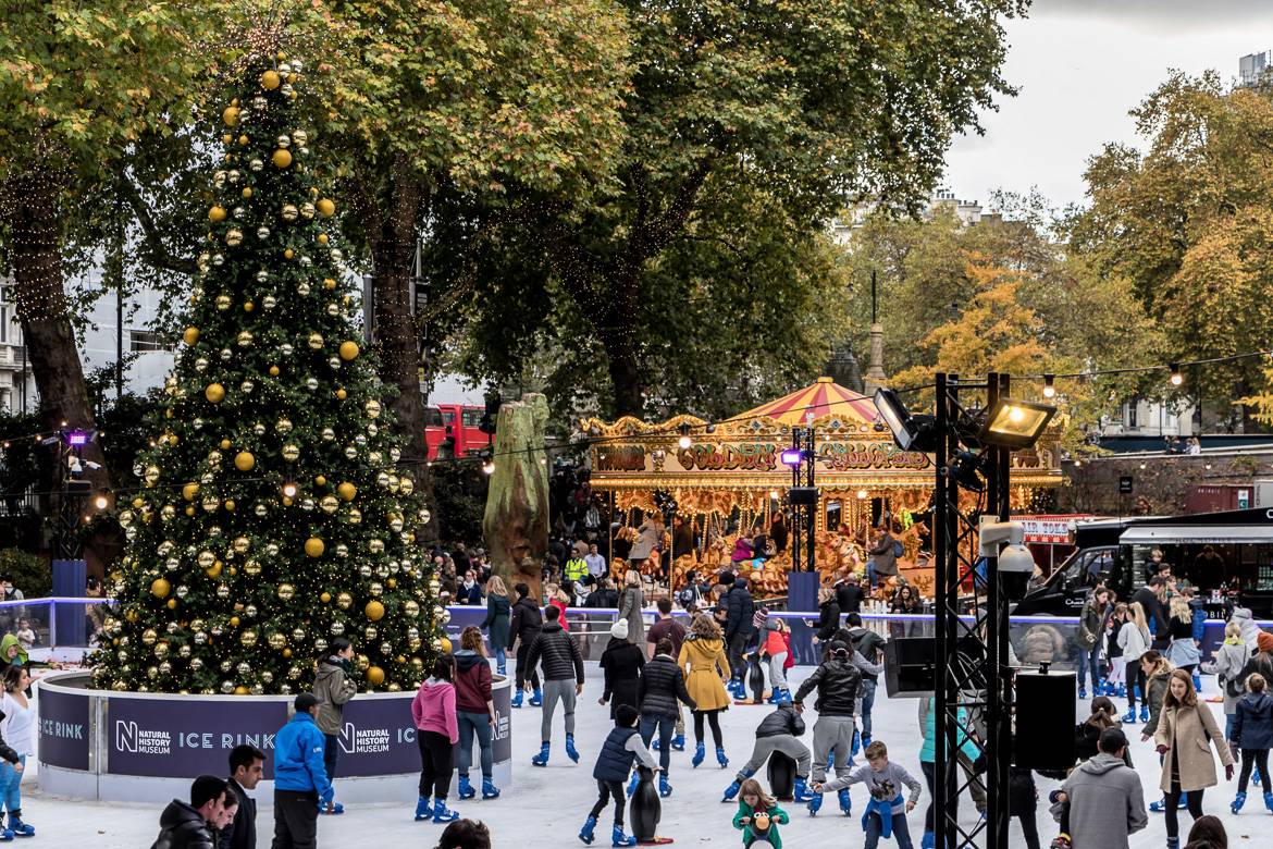 Imagen de una pista de hielo con un árbol de Navidad y un tiovivo