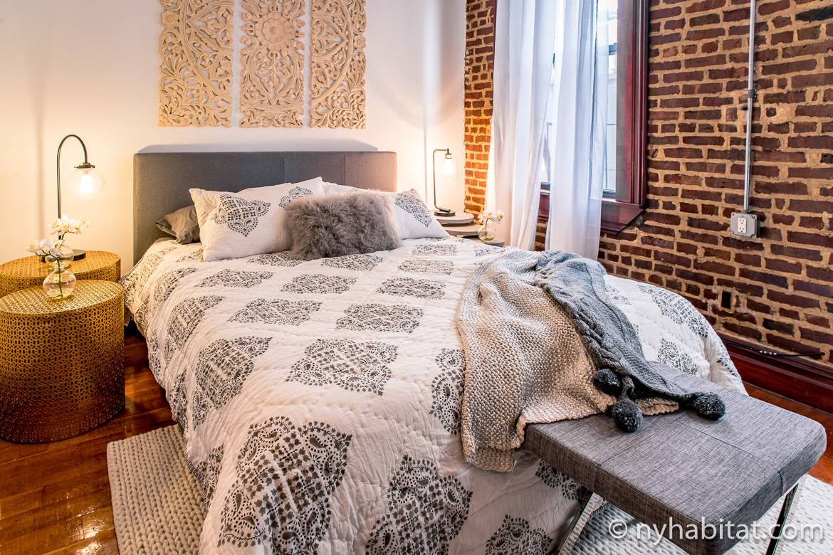Imagen del dormitorio del apartamento NY-17254 en West Village con pared de ladrillo y cómoda cama