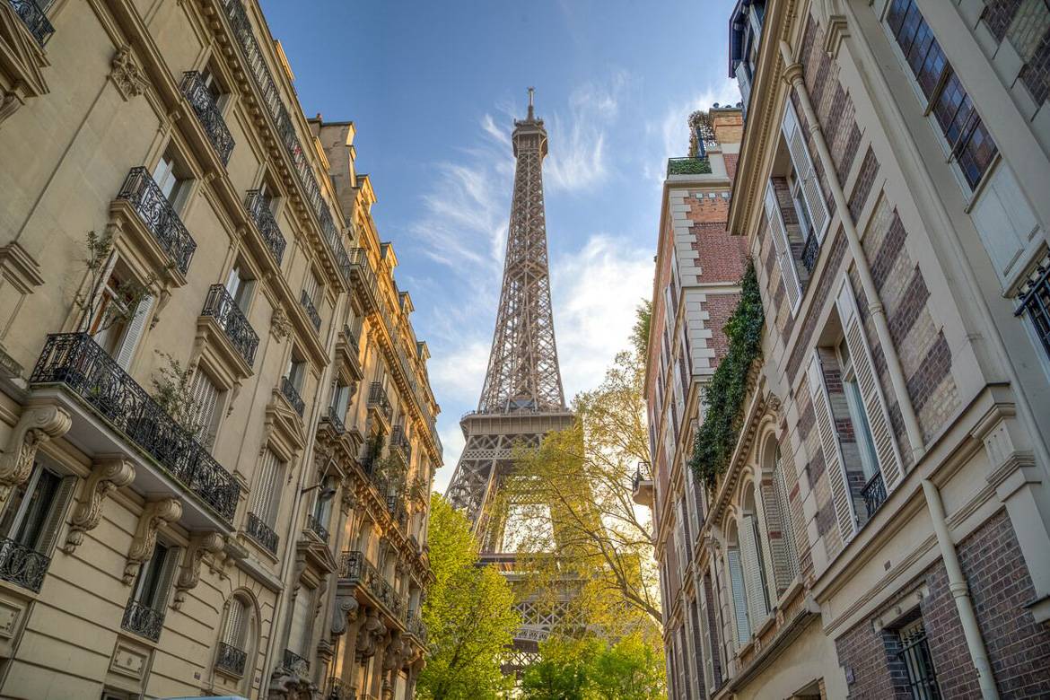 Imagen de la Torre Eiffel con edificios parisinos a los lados.