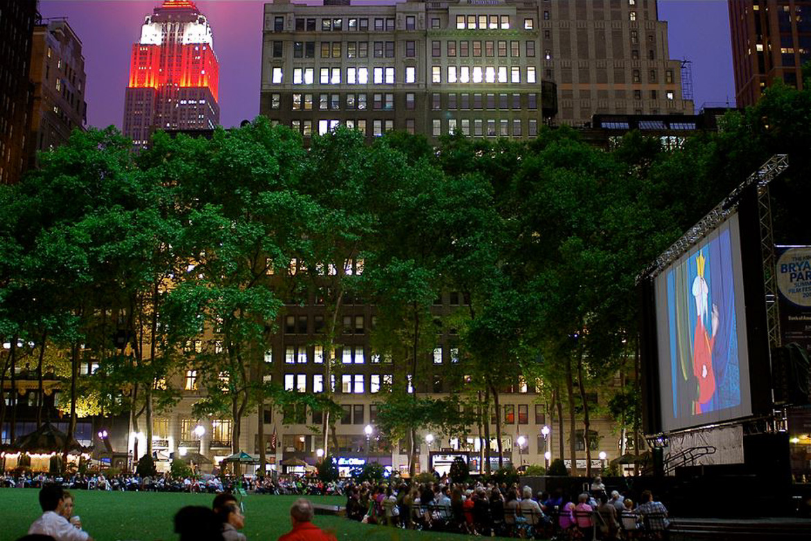 Imagen de gente disfrutando de una película al aire libre en Bryant Park con el Empire State Buiding al fondo
