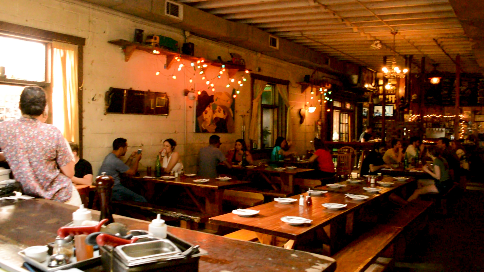 Imagen de jóvenes disfrutando de comida y bebida en un bar en Bushwick, Brooklyn.