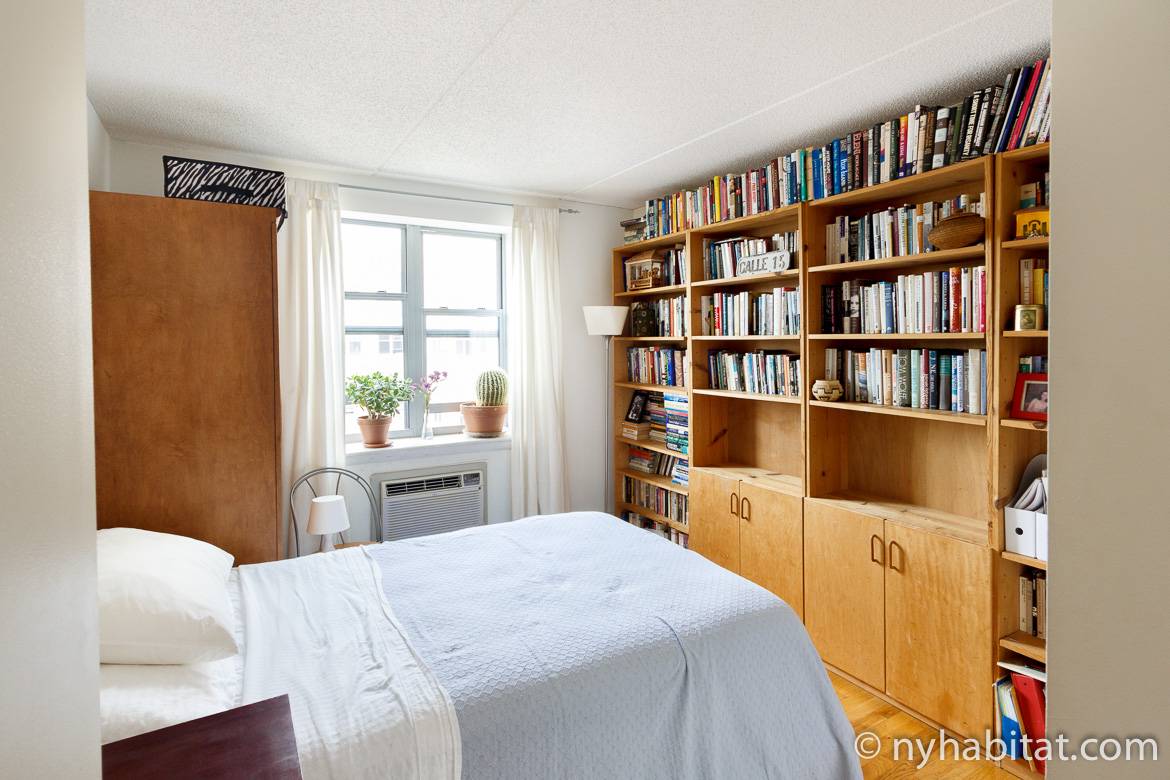 Imagen del dormitorio del NY-16265 con estanterías y cama de matrimonio.