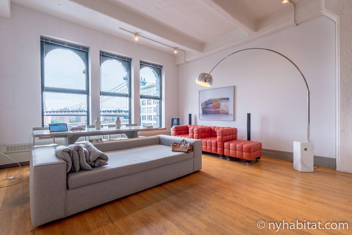 Imagen del salón del NY-14834 con sofá, lámpara y ventanas que se abren al Manhattan Bridge.