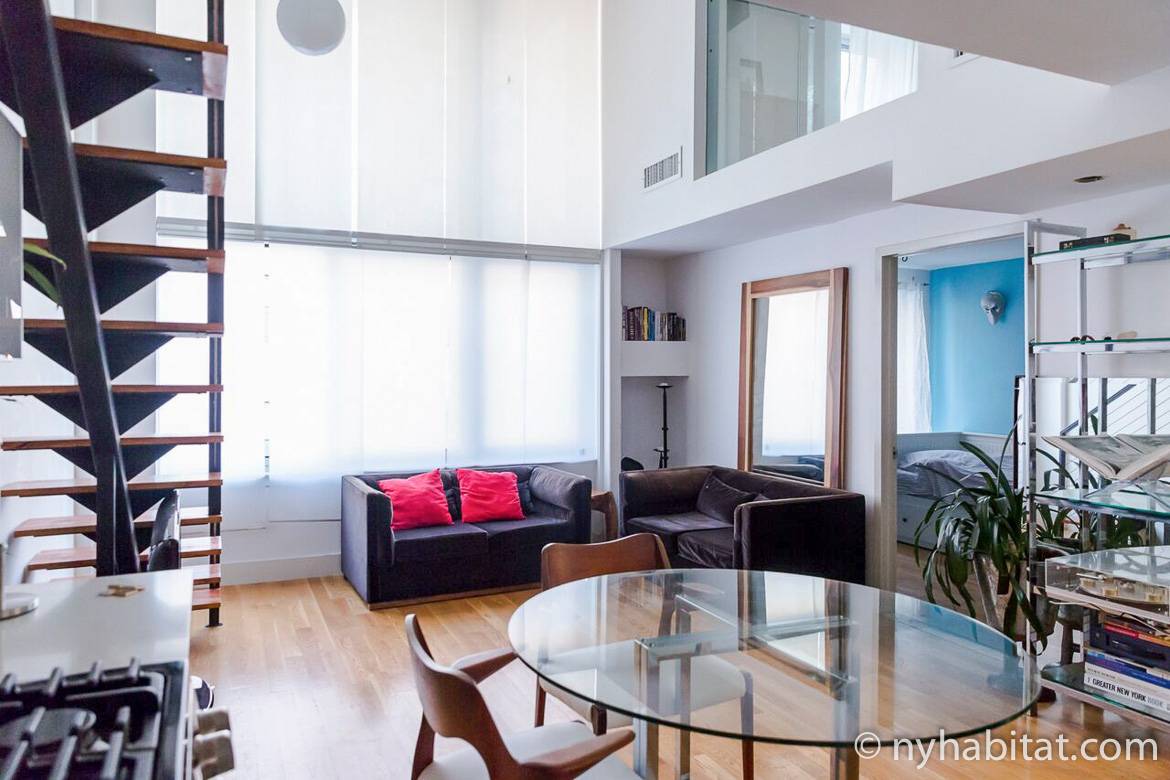 Imagen del salón del NY-15911 con sofá, mesa de comedor, sillas y escalera.