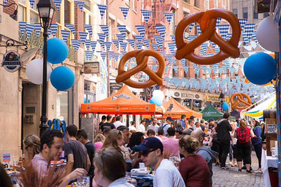 Imagen de la celebración del Oktoberfest al aire libre en Nueva York decorado con banderas y bretzels.