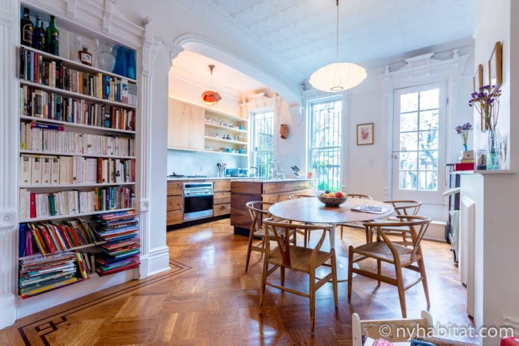 Imagen de un comedor en NY-15804 con una mesa de comedor, sillas, una lámpara de araña y estanterías.