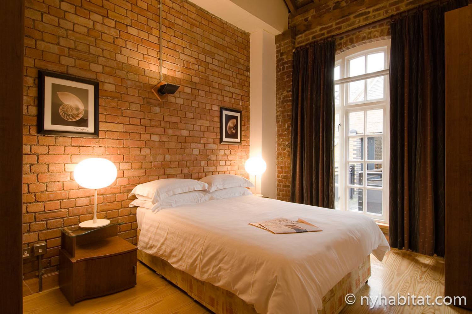 Imagen del dormitorio del LN-692 con paredes de ladrillo visto y cama de matrimonio.
