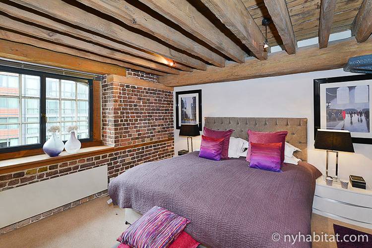 Imagen del dormitorio del LN-1581 con cama de matrimonio, mesita y adornos.