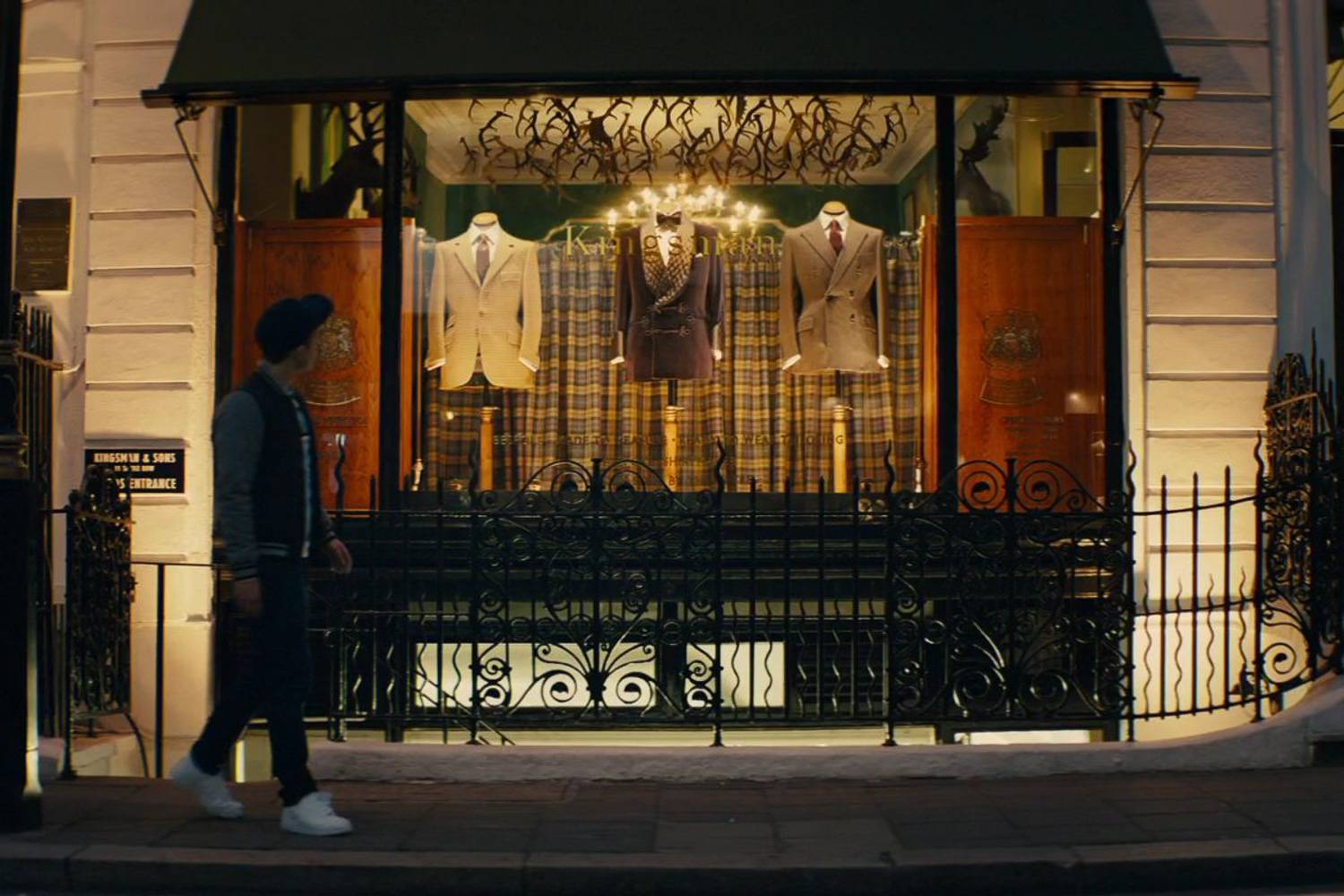 Imagen del actor Taron Egerton caminando por la calle frente a la sede de los Kingsman en Kingsman: Servicio secreto.