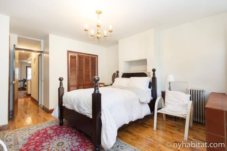 Plan-NY-Dia-San-Valentin-economico-NY-17129-Harlem-alojamiento-dormitorio Imagen del dormitorio del NY-17129 con una cama doble, silla y armario.