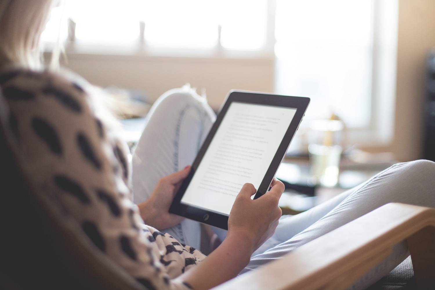 Imagen de una mujer leyendo un documento en una tablet.