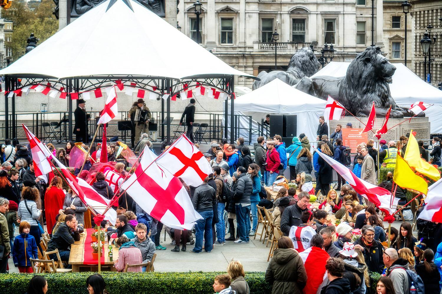 Imagen de gente reunida el día de St. George en Trafalgar Square con carpas y banderas inglesas.
