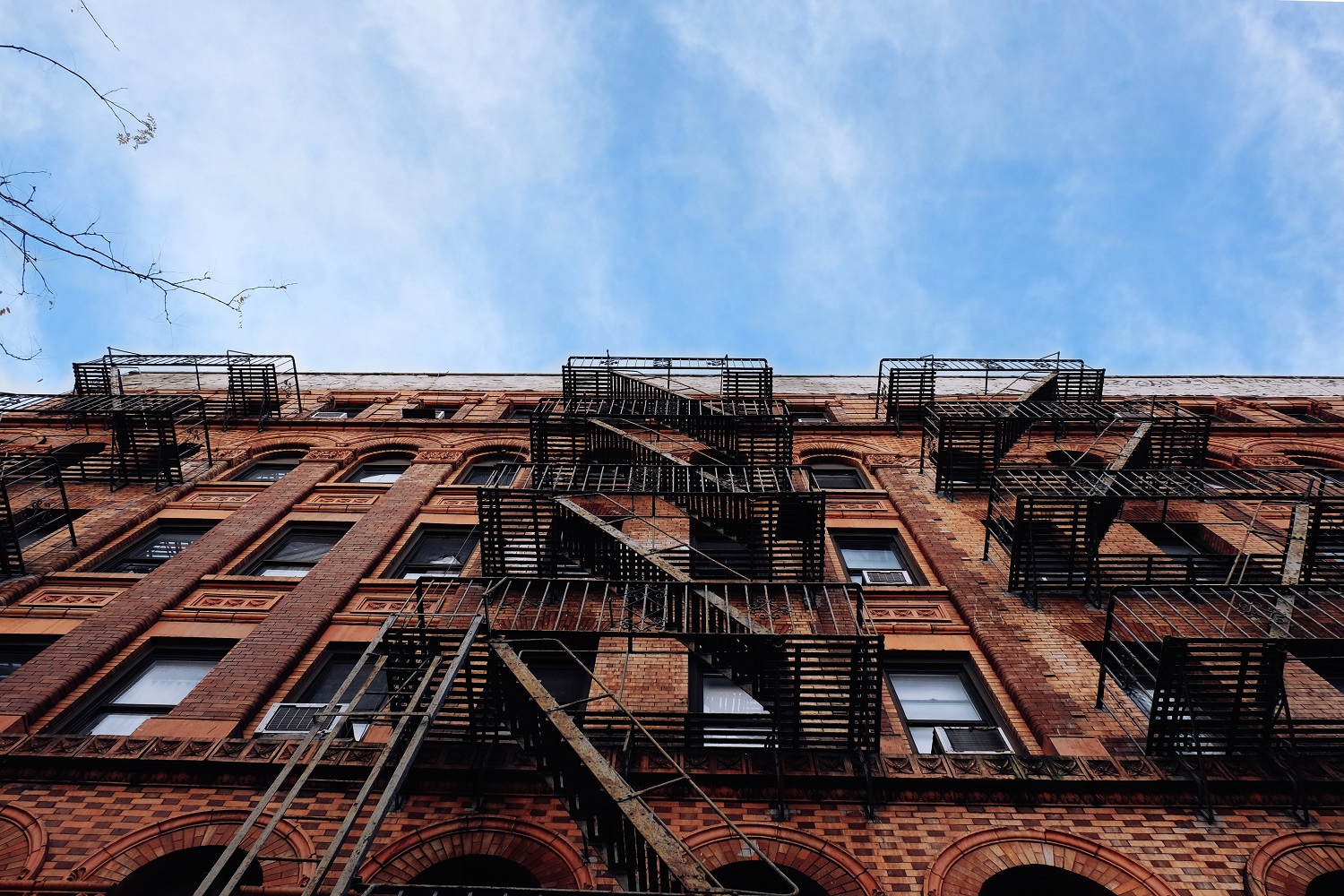 Imagen de una fachada de ladrillo de un edificio de apartamentos con salidas de emergencia en Nueva York.