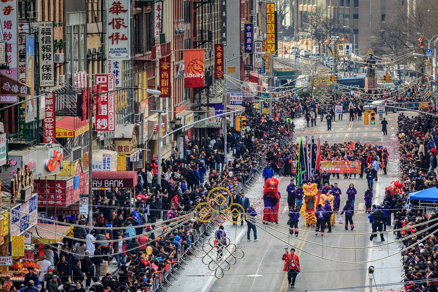 Vista aérea de una calle de Chinatown con un desfile por el Año Nuevo chino, con carteles escritos en chino
