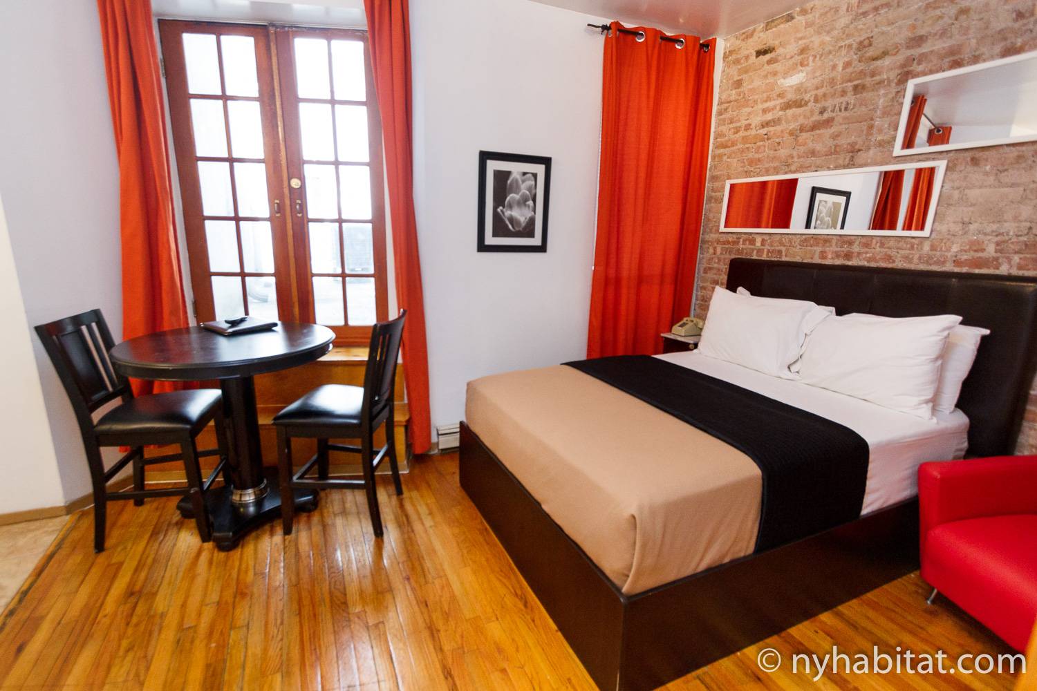 Imagen del apartamento vacacional de un dormitorio NY-15300 en el Lower East Side con cama, decoración en rojo y ladrillo visto