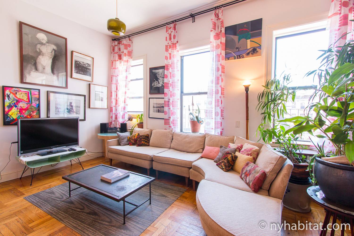 Imagen del salón del apartamento amueblado de tres dormitorios NY-16964 en el Lower East Side, con un gran sofá en curva y una televisión
