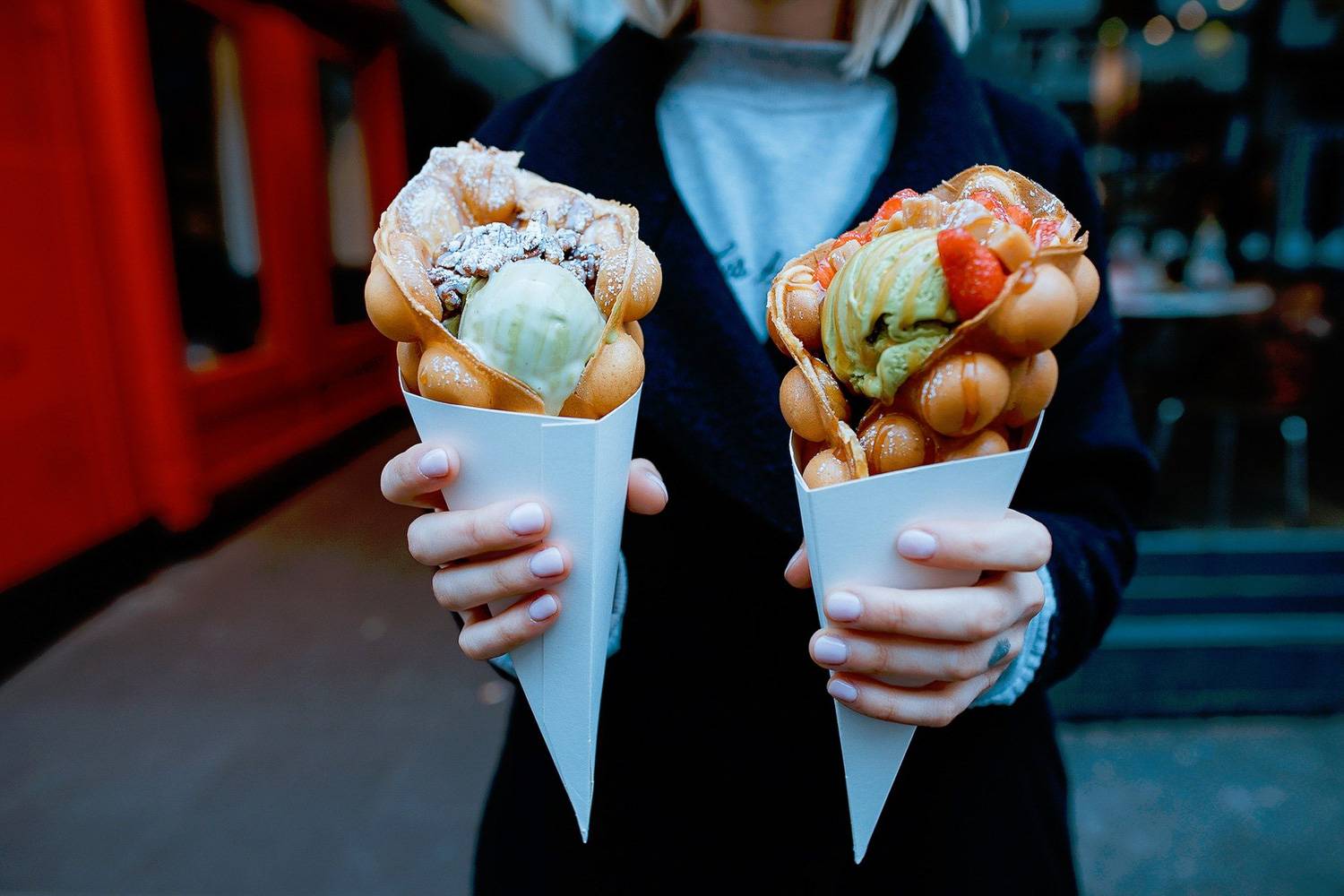 Imagen de una persona sosteniendo dos conos de helado muy singulares
